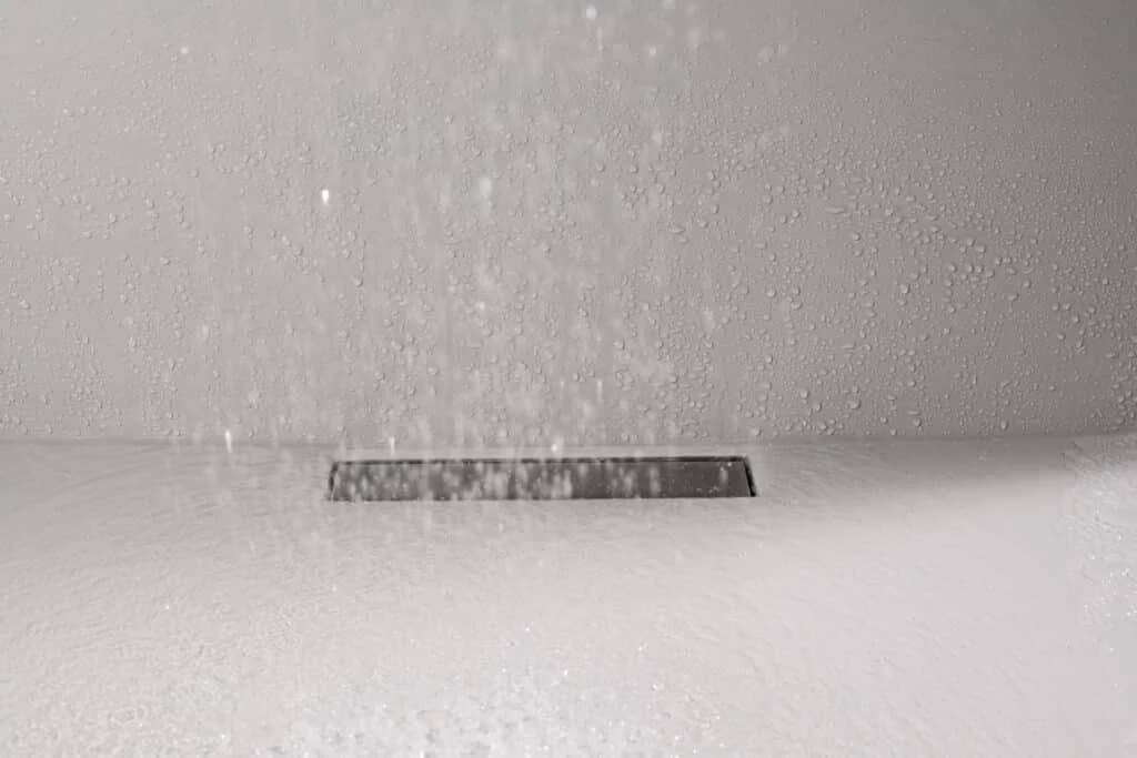 Fugenlose Dusche mit laufendem Wasser und wandbündiger Edelstahl-Ablaufrinne
