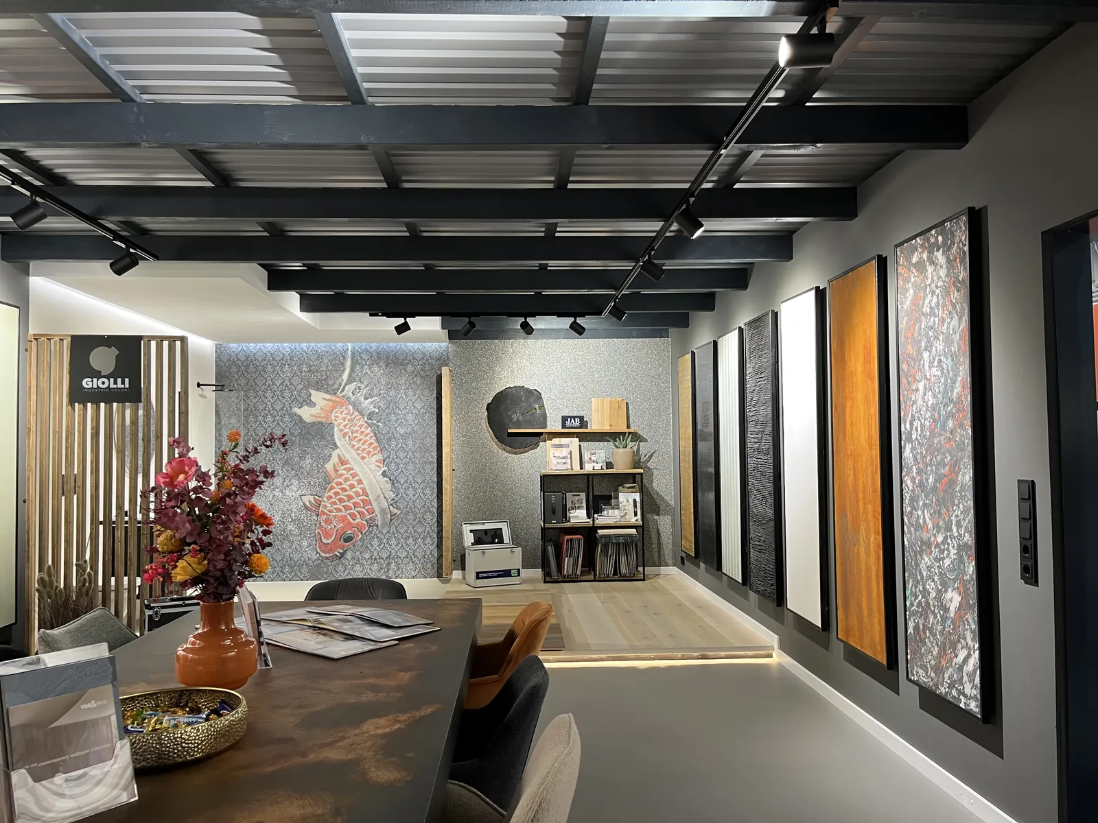 Beratungstisch mit Blumen vor dem Giolli-Bereich und der Koi-Wand im Terra Lilia Showroom